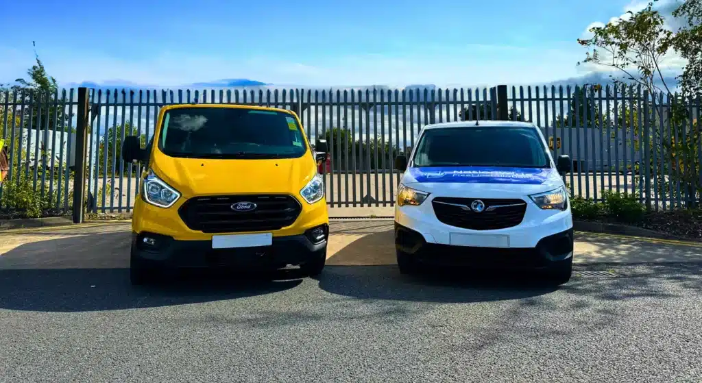 Two commercial fleet vans—a yellow Ford Transit and a white Vauxhall Combo branded with Nationwide Fleet Installations—parked side by side