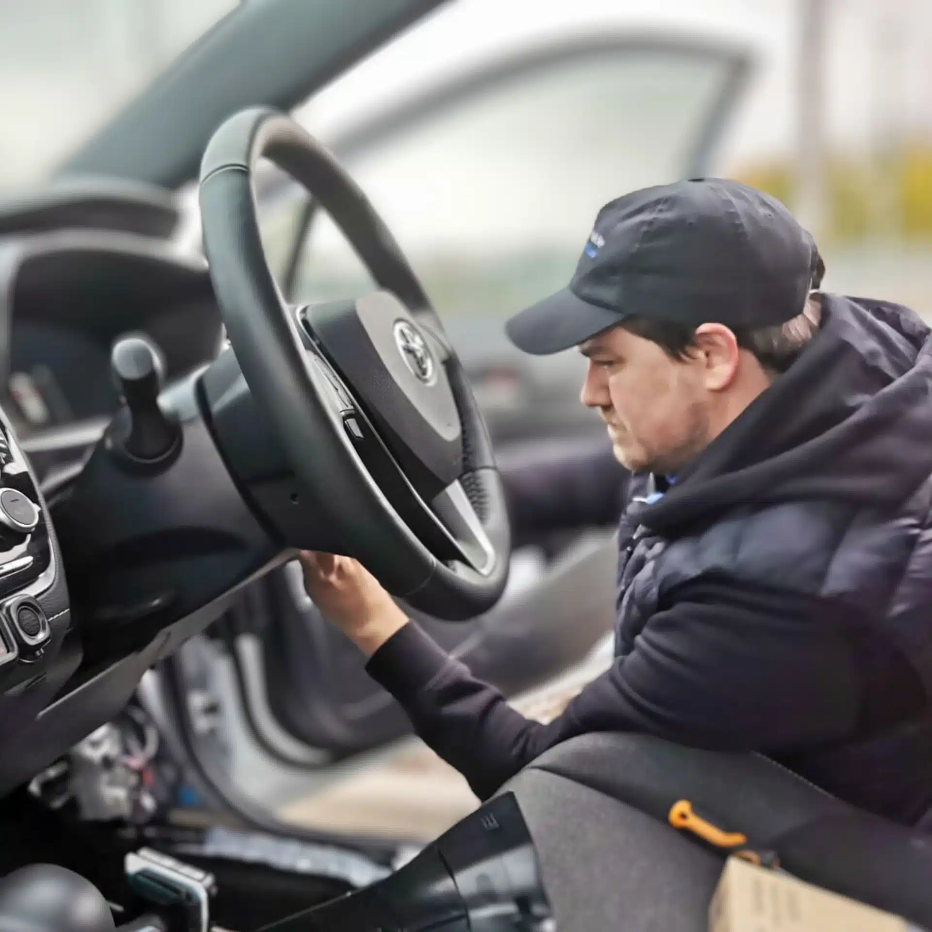 Engineer installing a GPS tracking device inside a vehicle