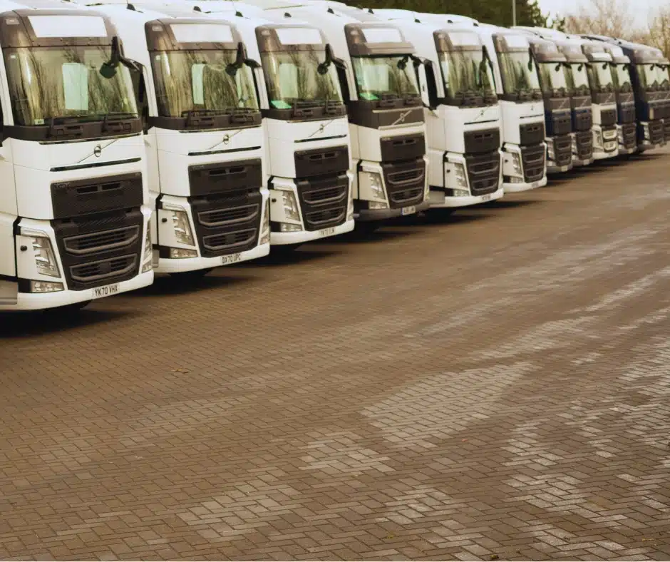 Line-up of white HGVs parked in a fleet yard