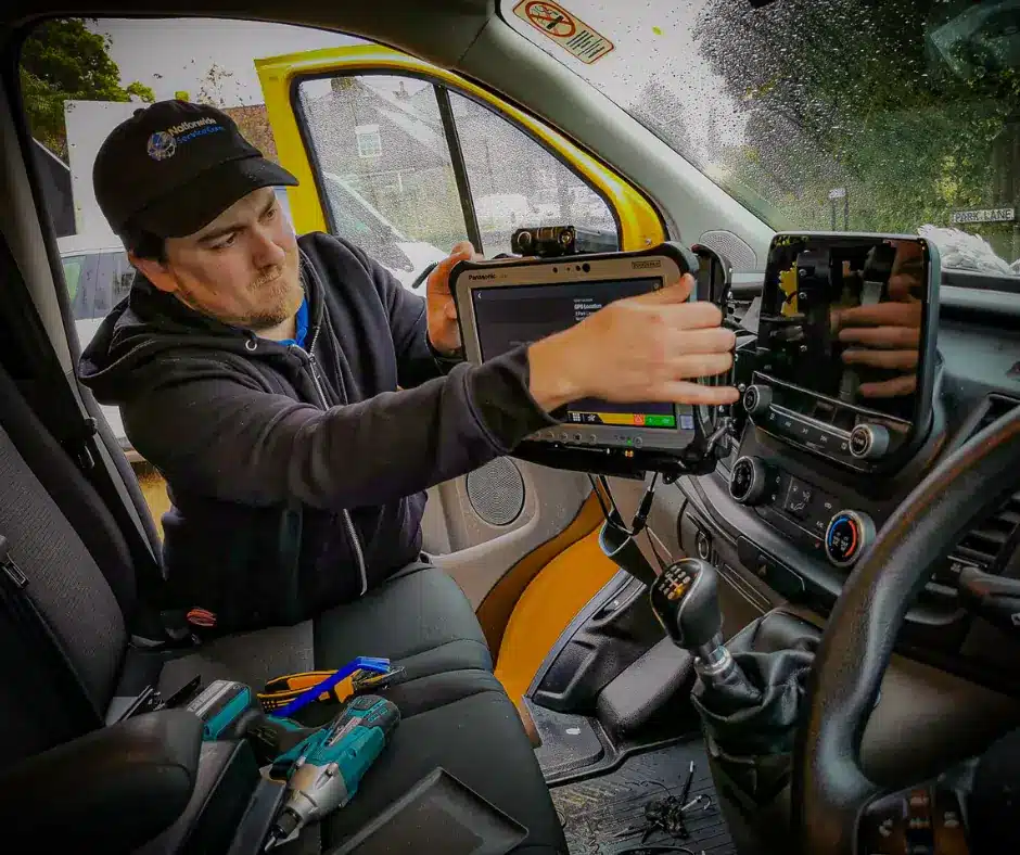 Technician professionally installing rugged tablet mount in commercial vehicle