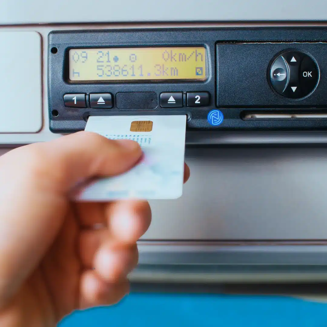 tachograph unit with a driver card being inserted and odometer data displayed