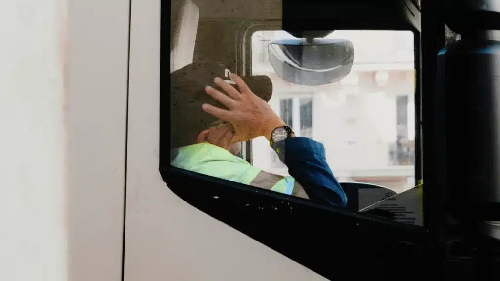 A lorry driver is pictured resting inside the cab, with his hand on his head