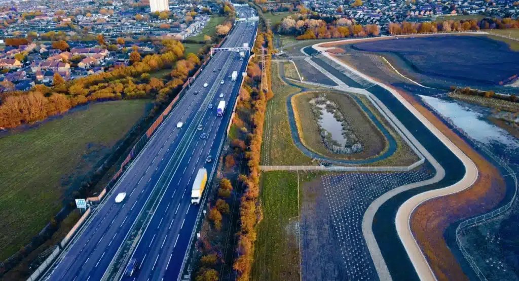 Aerial view of UK motorway with mixed-use development site, ideal for fleet-wide video telematics deployments
